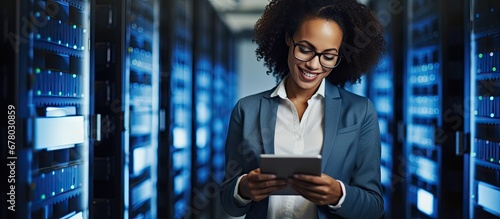 Female e business entrepreneur enjoys using a tablet while IT engineer and system administrator work in a cloud server farm Copy space image Place for adding text or design