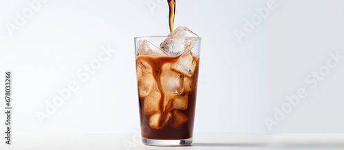 Cream being poured into cold coffee in a tall glass showcasing the drink s texture on a light gray background Copy space image Place for adding text or design