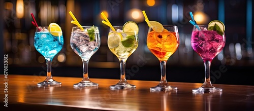 Five vibrant gin tonic drinks in wine glasses on bar counter in establishment Copy space image Place for adding text or design