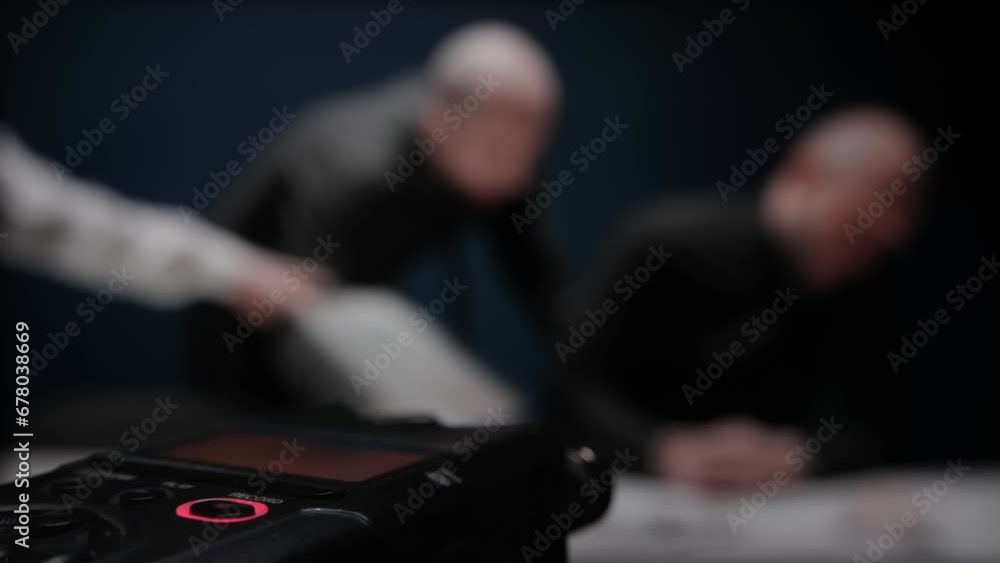 Close up digital voice audio recorder, blinking REC button. Police interrogation without lawyer. Detective cop shows evidence bag. FBI agent threatens mafia. Officers are trying to extract confession Close up digital voice audio recorder, blinking REC button. Police interrogation without lawyer. Detective cop shows evidence bag. FBI agent threatens mafia. Officers are trying to extract confession