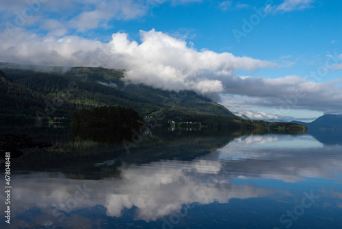 Clouds and mountains reflecting on fjord in Norway