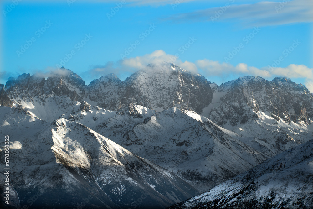 Snowy mountains and white clouds in the blue sky. Snowy mountain view from Huser Plateau. Rize, Türkiye.