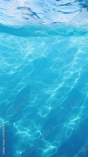 Clear blue water in a pool, with sunlight shining through and creating a beautiful reflection.