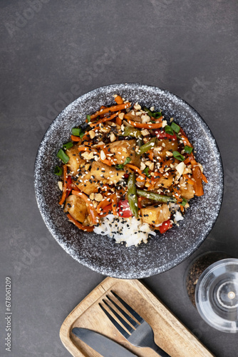 Bowl with tasty rice, meat and vegetables on dark background top view, flat lay