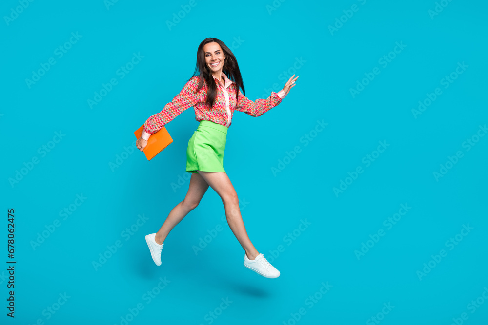 Full length photo of glamour charming lady dressed striped trendy clothes running empty space store mall isolated on cyan color background