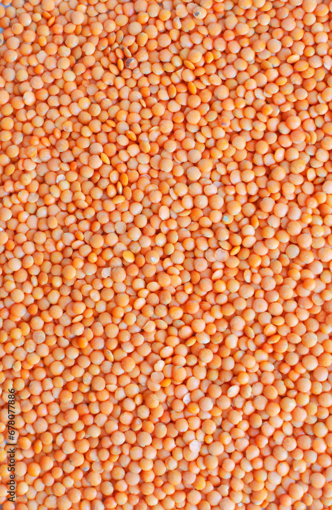 Orange lentils background. Pattern. The concept of proper nutrition. Vegan and vegetarian food. Rustic style. Vertical orientation.