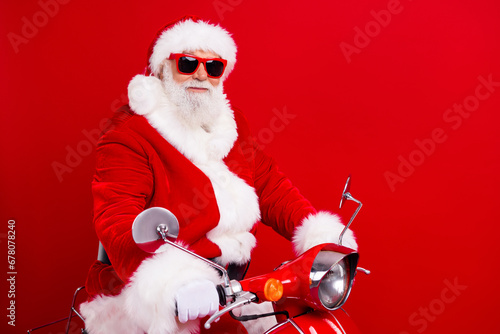 Full size photo of cool positive grandfather wear stylish santa costume glasses travel on red scooter isolated on red color background