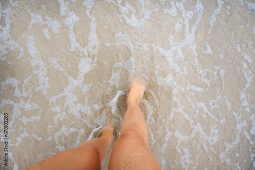 A beautiful girl in a bikini on a wild beach, bathing in the clear waves of the warm sea. a heavenly place and a beautiful model.