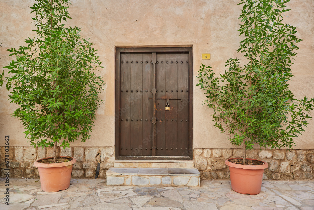 Brown wooden door at the entrance to arab house in old Dubai Brown wooden door at the entrance to arab house in old Dubai