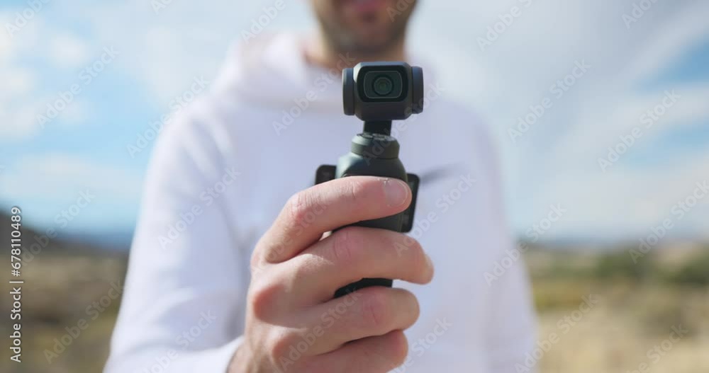 Vlogger showing modern DJI Osmo Pocket 3 stabilized intelligent tracking mobile gimbal camera for creative videography Vlogger showing modern DJI Osmo Pocket 3 stabilized intelligent tracking mobile gimbal camera for creative videography