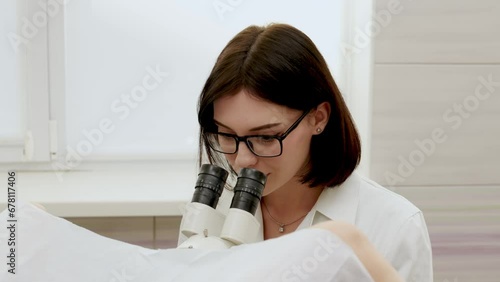 Patient and doctor in a gynecological office during a colposcopy procedure. A gynecologist looks through a digital colposcopic microscope, studying women's diseases. Medical test. photo