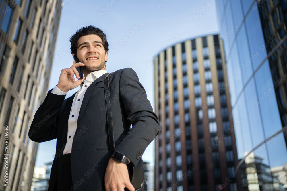 A businessman in a suit uses a phone. A successful confident man is talking on the phone with a bank manager. A businessman in a suit uses a phone. A successful confident man is talking on the phone with a bank manager.