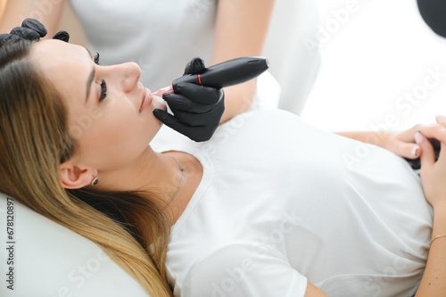 Banner Process woman applying permanent tattoo makeup on lips in beautician salon photo