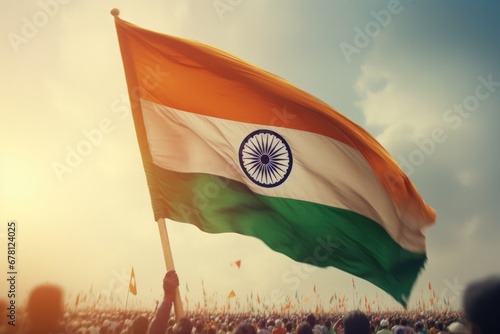 A person proudly holds an Indian flag in front of a lively crowd. This image can be used to depict patriotism, national celebrations, cultural events, or demonstrations.