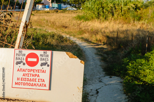 Sign in Greek prohibiting motorbikes photo
