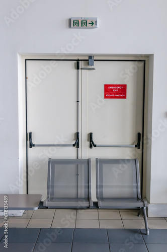 Emergency exit fire doors blocked by seating in a Greek airport making emergency evacuation impossible.