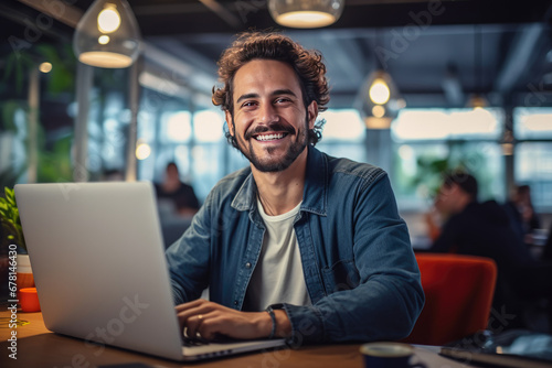 Portrait of attractive smiling man sitting in office and looking at camera.. photo
