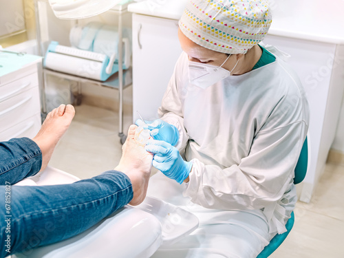 Female podiatrist doing chiropody in her podiatry clinic. Selective focus photo