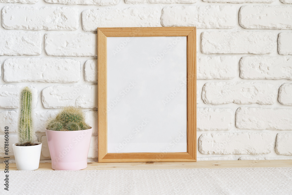 Square wooden photo frame and cactus plants on the table Square wooden photo frame and cactus plants on the table