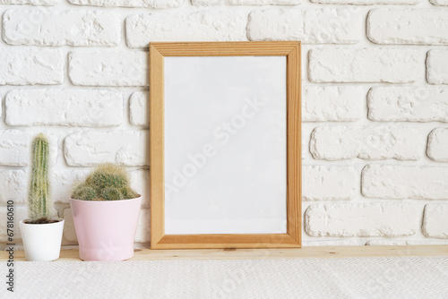 Square wooden photo frame and cactus plants on the table