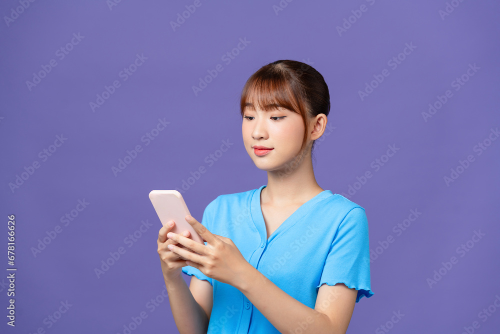 Young female student using cellphone showing like icon smiling isolated on purple background Young female student using cellphone showing like icon smiling isolated on purple background