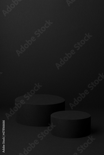 Abstract two black round podiums for cosmetic products, mockup on black background, vertical. Black stage template in elegant exquisite style for showing products, advertising, design, poster, card.