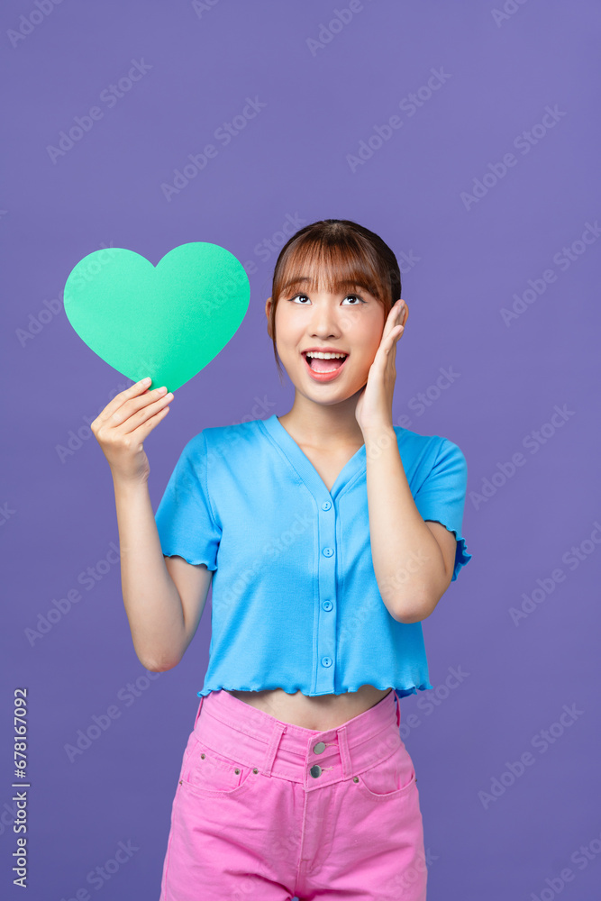 Young good mood beautiful stunning cute girl hold paper heart valentine day isolated on purple Young good mood beautiful stunning cute girl hold paper heart valentine day isolated on purple