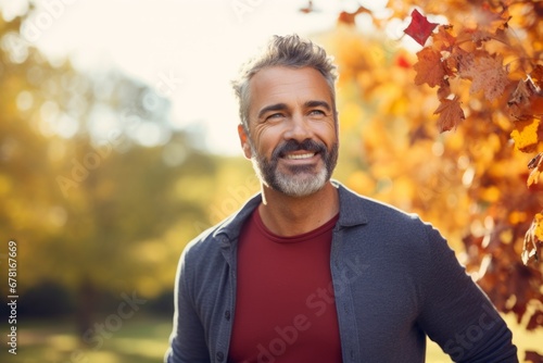 Portrait of a cheerful man in his 40s donning a trendy cropped top against a background of autumn leaves. AI Generation