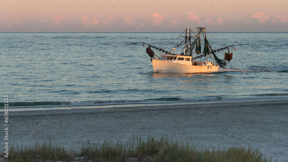 Shrimp boat along the North Carolina shoreline in the light of the setting sun.