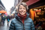 Portrait of a joyful woman in her 50s donning a durable down jacket against a bustling urban market. AI Generation