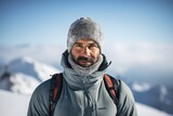 Portrait of a glad man in his 40s wearing a protective neck gaiter against a pristine snowy mountain. AI Generation