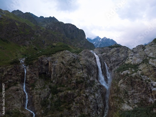 Aerial panorama of a Ushbi Waterfall among the Caucasian mountains, Stormy flow of mountain river Dolra. Summer vacation, hiking in Georgia