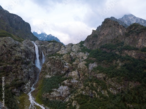Aerial panorama of a Ushbi Waterfall among the Caucasian mountains, Stormy flow of mountain river Dolra. Summer vacation, hiking in Georgia