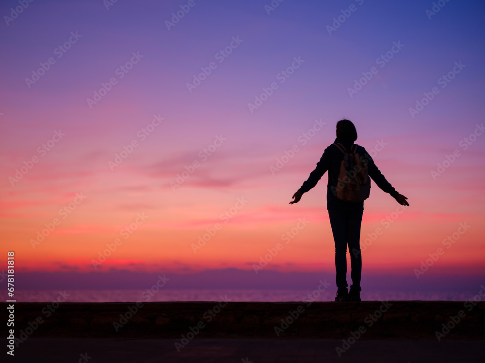 Woman tourist against colorful sunset sky. Travel, tourism concept. Active lifestyle.