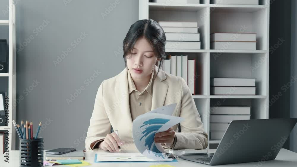 Asian woman sitting in office, businesswoman in finance and accounting is working, collecting financial documents to summarize financial statements, profit and loss statement, accounting concept. Asian woman sitting in office, businesswoman in finance and accounting is working, collecting financial documents to summarize financial statements, profit and loss statement, accounting concept.