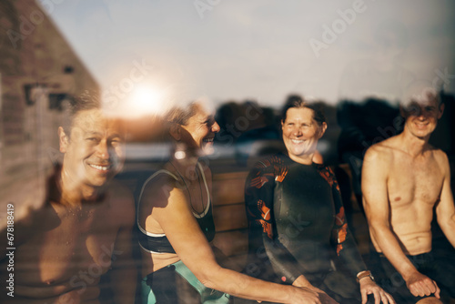 Smiling mature friends sitting in a beach hut after an ocean swim photo
