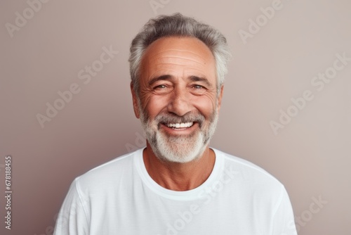 Portrait of a joyful man in his 60s wearing a simple cotton shirt against a pastel gray background. AI Generation