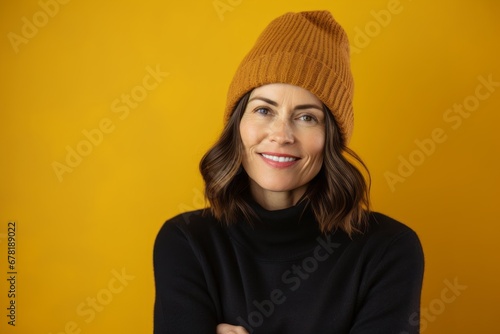 Portrait of a content woman in her 40s donning a warm wool beanie against a soft yellow background. AI Generation © CogniLens