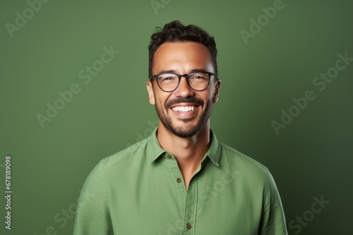 Portrait of a smiling man in his 30s wearing a simple cotton shirt against a soft green background. AI Generation