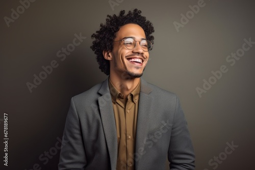 Portrait of a happy man in his 20s dressed in a stylish blazer against a soft gray background. AI Generation