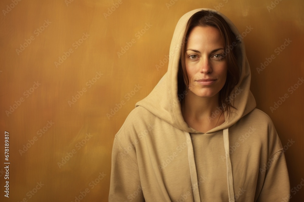 Portrait of a tender woman in her 40s sporting a comfortable hoodie against a soft brown background. AI Generation Portrait of a tender woman in her 40s sporting a comfortable hoodie against a soft brown background. AI Generation