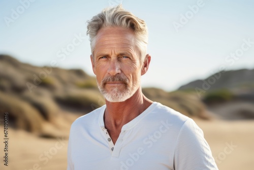 Portrait of a content man in his 60s wearing a breathable golf polo against a sandy beach background. AI Generation