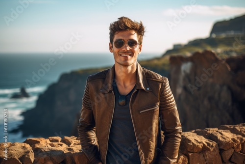 Portrait of a joyful man in his 20s sporting a classic leather jacket against a rocky cliff background. AI Generation