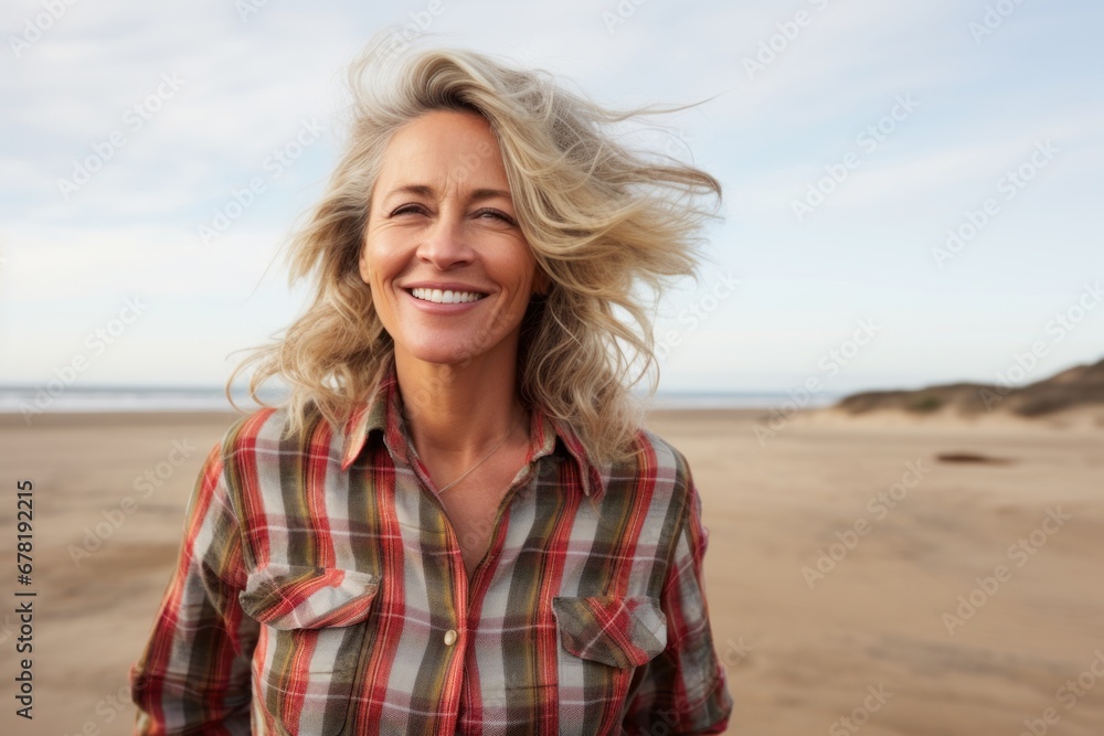 Portrait of a joyful woman in her 50s wearing a comfy flannel shirt against a serene dune landscape background. AI Generation Portrait of a joyful woman in her 50s wearing a comfy flannel shirt against a serene dune landscape background. AI Generation