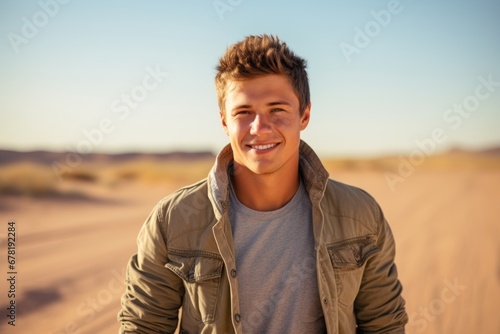 Portrait of a joyful man in his 20s wearing a rugged jean vest against a serene dune landscape background. AI Generation