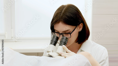 Patient and doctor in a gynecological office during a colposcopy procedure. A gynecologist looks through a digital colposcopic microscope, studying women's diseases. Medical test. photo