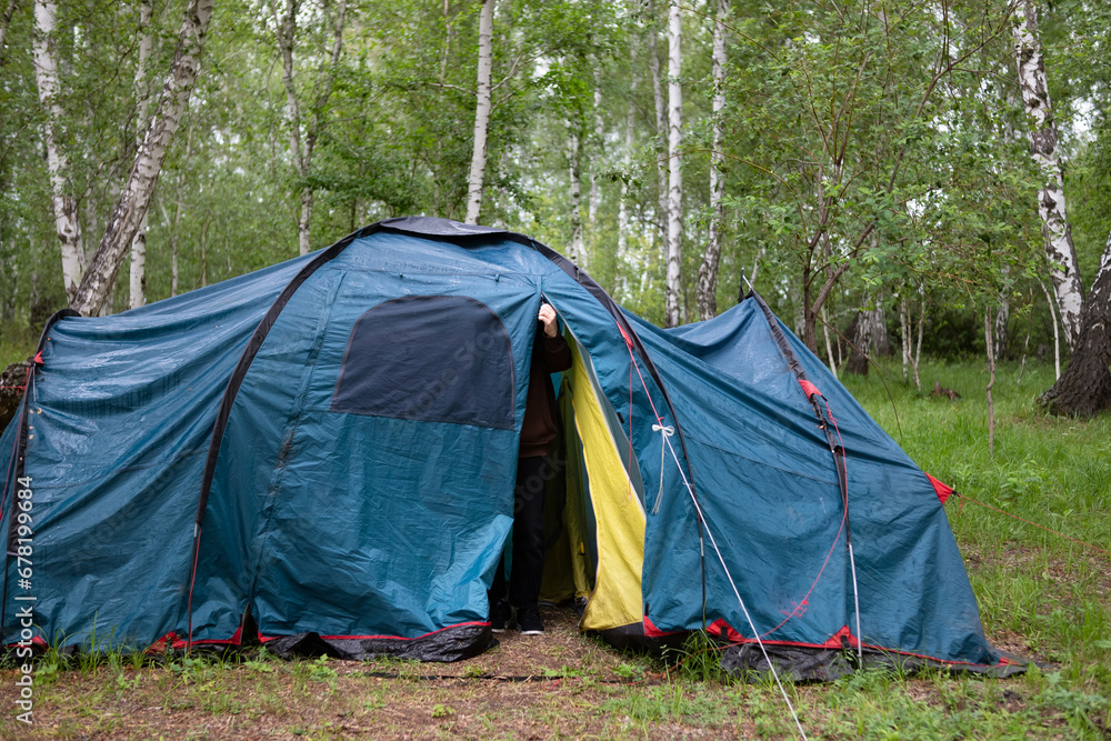 A woman sets up a tent in the forest