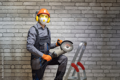 Worker is using angle grinder. Construction concept. Builder wearing in personal protective equipments.