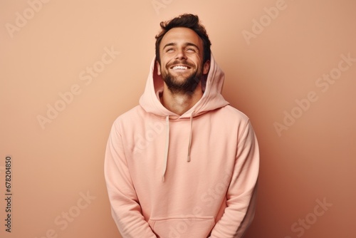 Portrait of a blissful man in his 30s sporting a comfortable hoodie against a pastel or soft colors background. AI Generation