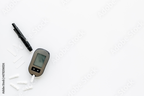 Medical device and diabetes concept - blood glucose meter with lancets photo